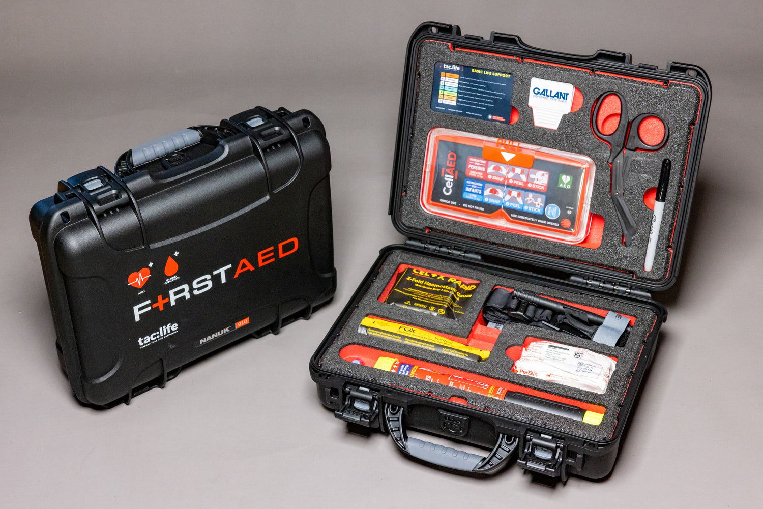 A red rectangular box with a white cross symbol on it, containing medical equipment for first aid response to trauma and cardiac incidents. The box is opened, revealing its contents, including a bleed control kit, Fire Safety Stick, and CellAED device. It can be mounted on walls or transported in vehicles, providing a versatile option for emergency preparedness.